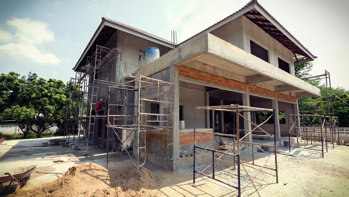 外壁工事中の家屋に職人が作業している新築現場